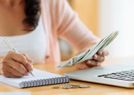 A woman managing a budget at a computer